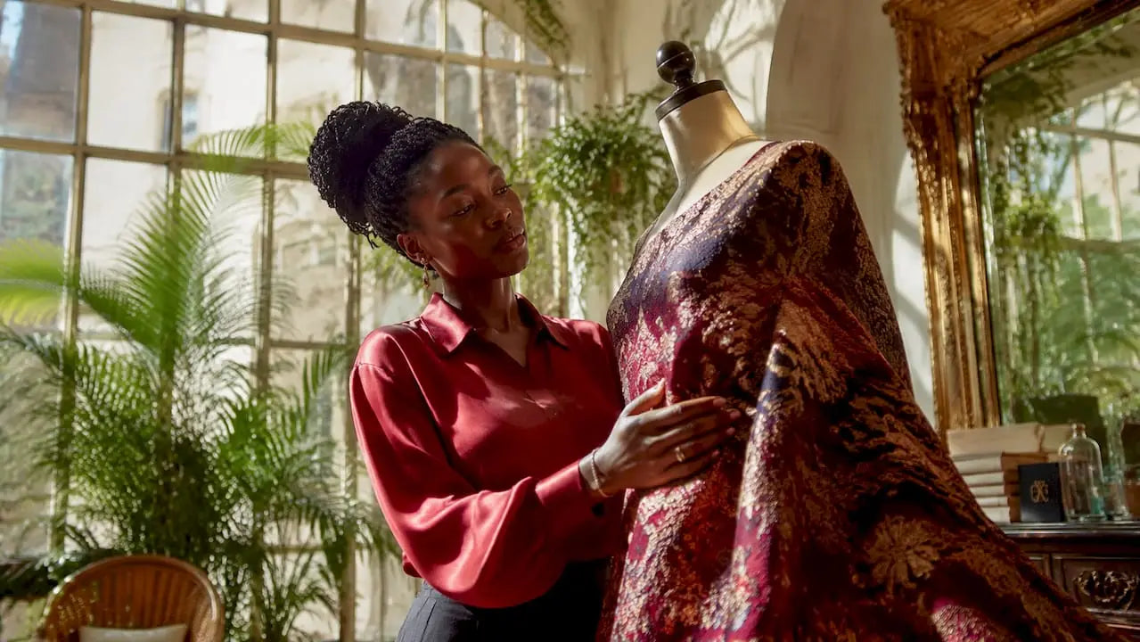 Une couturière inspecte minutieusement un tissu jacquard dans son atelier.
